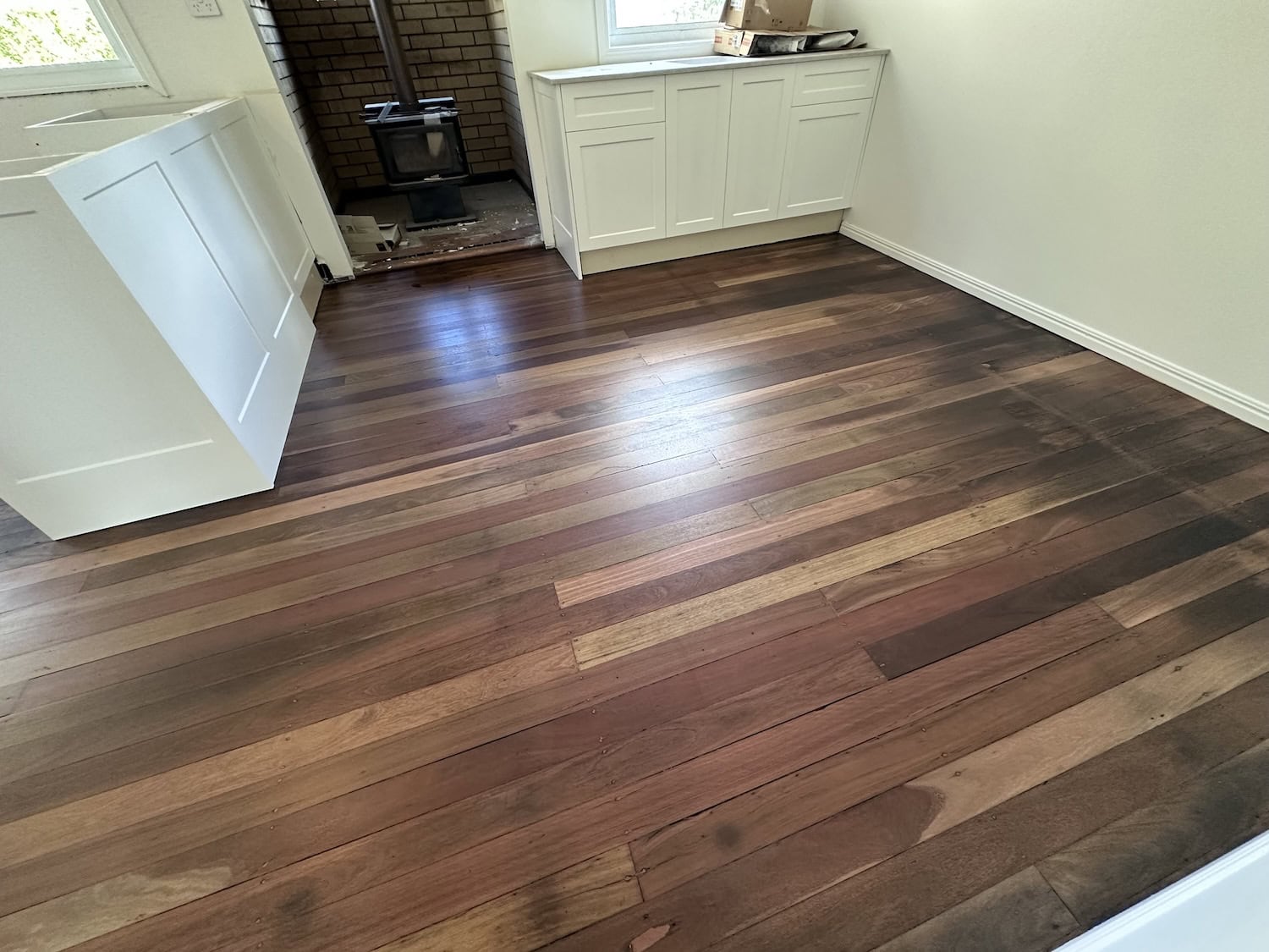 Beautiful hardwood flooring in a modern kitchen with white cabinetry — example finish for Holland Park timber floors