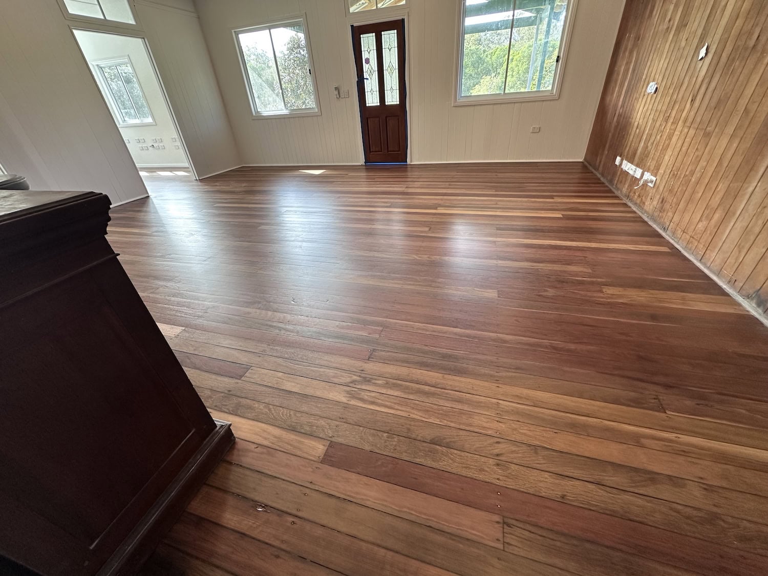 Beautiful hardwood flooring in a bright living room with large windows in Wilston Brisbane