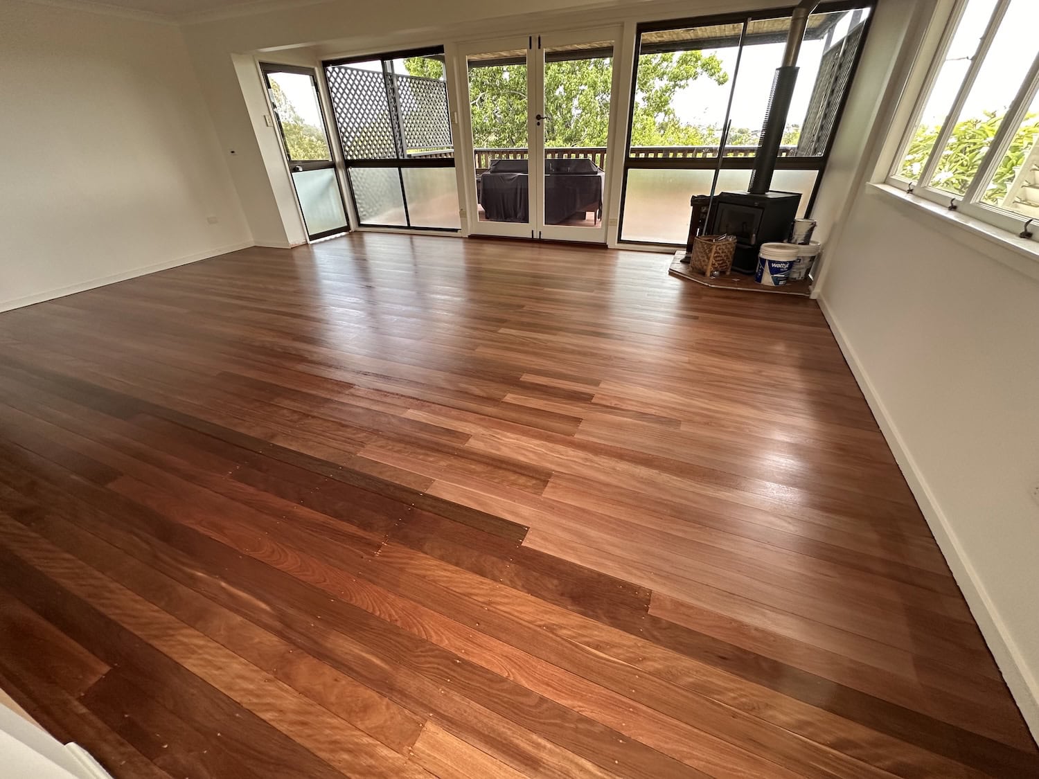 Hardwood flooring installation in a bright living room with large windows in Auchenflower Brisbane